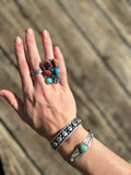 Navajo hand made ring with a mix of stones such as purple spiny, red spiny and orange spiny as well as two turquoise stones.