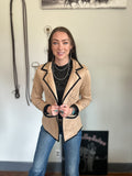 Women wearing a western blazer that is a faux suede and has boot stitch details. she is also wearing a lot of turquoise jewelry 