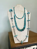 Hand made turquoise necklaces on a necklace stand to display them. the turquoise is a bright blue, there are 3 necklaces in the stack 